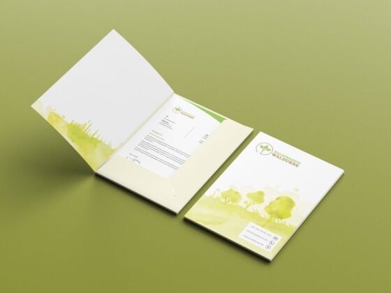 Offener Ordner mit grünen Naturmotiven, darin Dokumente mit Baumlogo und Schrift "Internationaler Tag der Wälder". Offener Ordner mit grünen Naturmotiven, darin Dokumente mit Baumlogo und Schrift "Internationaler Tag der Wälder".